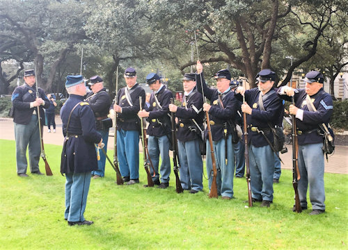 Lt. Cmdr. Edward Lea, USN, Camp #2 Member load their muskets in praperation of firing.